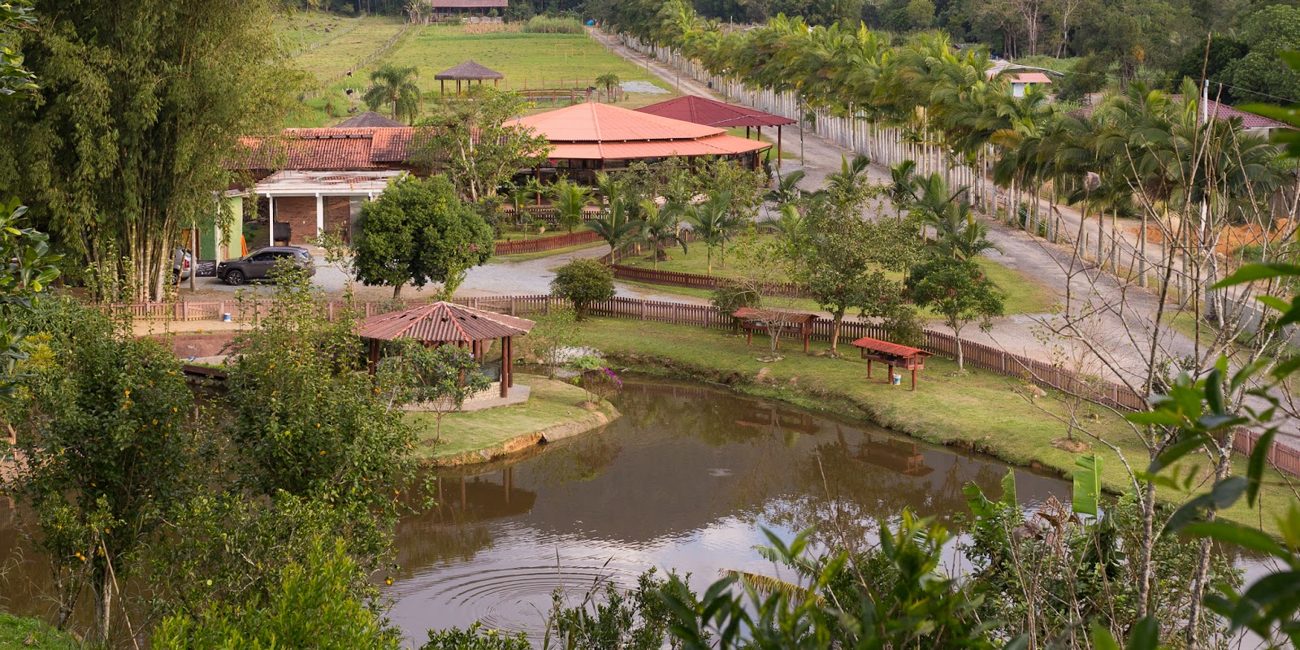 Vista do alto do Eco Park com lago, salões e jardins