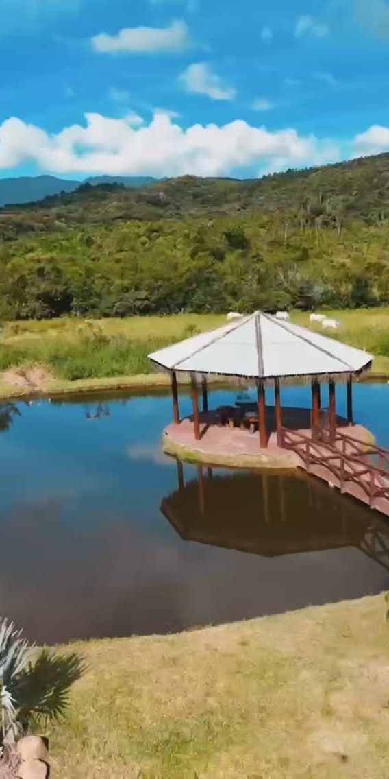 Lago com quiosque e as montanhas ao fundo